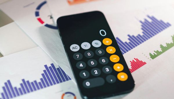 La calculatrice du smartphone est posée sur des statistiques imprimées